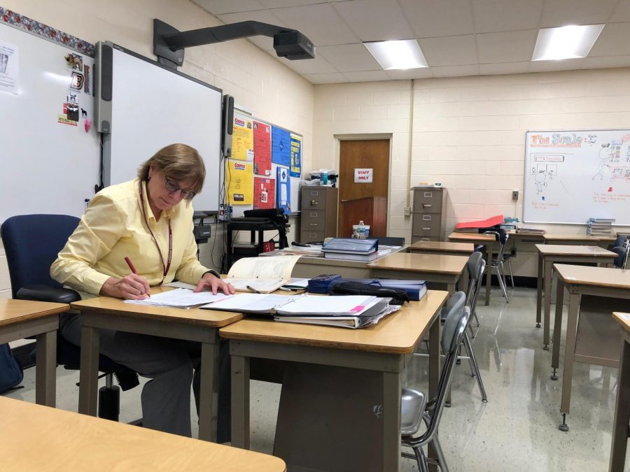 Business Technology teacher Sharyn Setzer grades assignments at her desk at the high school. The Board of Education voted Sept. 24 to change the school district’s grading policy.