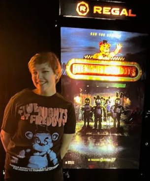 Regal Cinemas in Phillipsburg has been showing the Five Nights at Freddy’s movie since its release Oct. 27. The Streak Editor in Chief Roisin McCluskey stands next to the poster outside of the movie theater after seeing the movie. (Photo courtesy of Maebh McCluskey)