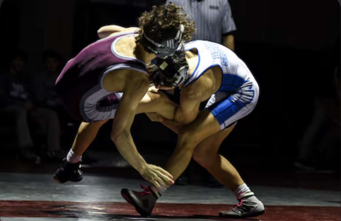 The wrestlers pile on before their match against Ridge Jan. 15, 2025 (Photo courtesy of Lors Photography)